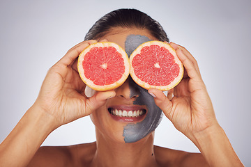 Image showing Hands with grapefruit, skincare and face mask with clay, charcoal or natural beauty product for wellness, detox or nutrition. Fruit, woman in funny pose and healthy cosmetics for facial care