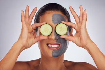 Image showing Face, cucumber and mask with a model woman in studio on a gray background for an antiaging facial treatment. Eyes, skincare and fruit with a young female person using cosmetic lay on her face