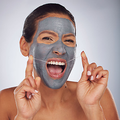 Image showing Beauty, face mask and a woman flossing teeth for skincare, dental hygiene and wellness. Happy, portrait and a model or girl with gear for tooth cleaning and a facial isolated on a studio background