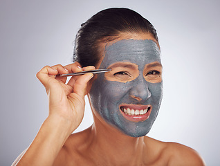 Image showing Portrait, eyebrow tweezers and a woman with a face mask for skincare, grooming and female beauty. Sore, cosmetics and a model with gear for hair and a facial isolated on a white background in studio