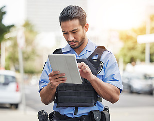 Image showing Police, tablet and patrol with a man officer outdoor on the street, using the internet to search during an investigation. Technology, information or law enforcement with a male security guard on duty