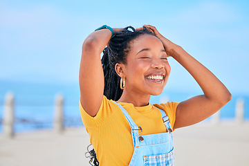 Image showing Face, smile and hair with a black woman on a blurred background by the ocean during summer vacation. Eyes closed, happy and braids with a young female person outdoor on the promenade for a holiday