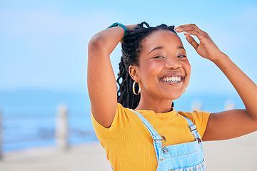 Image showing Portrait, smile and hair with a black woman on a blurred background by the ocean during summer vacation. Face, happy and braids with a young female person outdoor on the promenade for a holiday