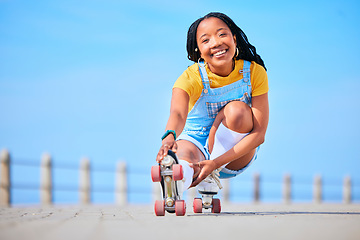 Image showing Portrait, roller skating and balance with a black woman by the sea, on the promenade for training or recreation. Beach, sport and smile with a happy young teenager in skates on the coast by the ocean