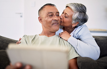 Image showing Marriage, kiss and senior man or woman on sofa for retirement or quality time in home. Couple, hug and elderly man or woman with tech in living room for bonding together with internet on couch.