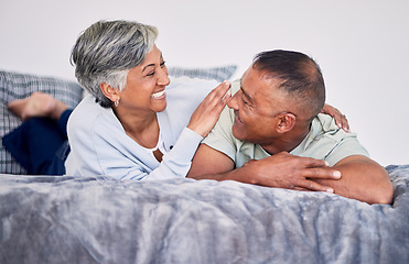 Image showing Love, conversation and mature couple on their bed while relaxing, bonding and spending time together. Happy, smile and senior man and woman in retirement resting, talking and lying in bedroom at home