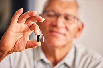 Image showing Hand holding hearing aid, senior man and tech for ears, health and wellness for retirement in nursing home. Elderly person with disability, audio or sound technology to listen in closeup at house