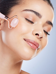 Image showing Happy woman, beauty or rose quartz roller for face massage, healthy skincare on studio background. Glow, grooming treatment or model smiling with dermatology facial cosmetics or product to relax