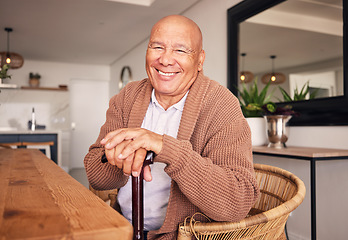 Image showing Portrait, walking stick and a senior man with a disability sitting in the living room of his home during retirement. Smile, cane and relax with an elderly person at the dining room table in his house