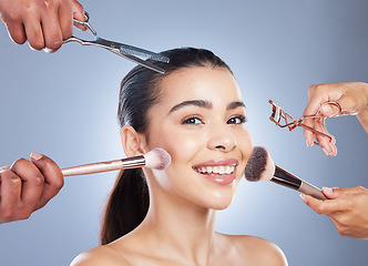 Image showing Hands with brush, makeup and portrait of woman in studio for wellness, beauty and cosmetics on blue background. Cosmetology, salon and face of girl for cosmetic application, foundation and products