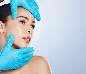 Image showing Woman, plastic surgery and gloves on face in studio, check and cosmetics with mockup space by background. Young girl, model and surgeon hands with thinking, inspection and measurement for aesthetic