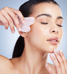 Image showing Gua sha, massage and asian woman with skincare tool in studio for anti aging, circulation or fine lines on grey background. Rose quartz, beauty and lady model with face crystal or lymphatic drainage