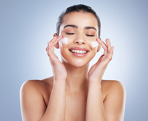 Image showing Skincare, hand and happy woman with face cream in studio for anti aging, wellness or hydration on grey background. Facial, smile and latino model with sunscreen, lotion or beauty mask application