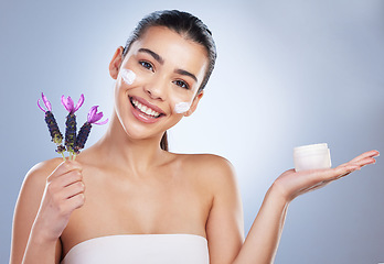 Image showing Beauty, cream and woman with lavender flower in studio for skincare product and natural glow. Portrait of happy female model on a gradient background for facial shine, cosmetics and face moisturizer