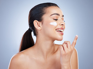 Image showing Skincare, hand and happy woman with face cream in studio or anti aging, collagen or hydration on grey background. Finger, smile and lady model with facial sunscreen, lotion or beauty mask application