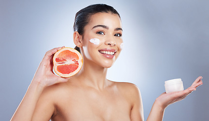 Image showing Skincare, face cream and woman with grapefruit in studio for a natural, organic or health facial routine. Beauty, self care and female model with citrus fruit and spf for treatment by gray background