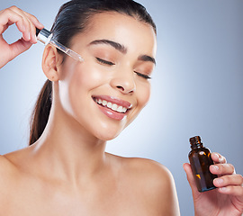 Image showing Skincare, oil serum and face of woman in studio for wellness, health and product. Dermatology aesthetic, salon and female with liquid pipette, vial or dropper for moisturizer, cosmetics and beauty