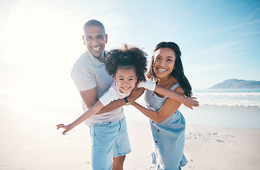 Image showing Beach, portrait and parents flying their kid on the sand by the ocean on a family vacation. Happy, smile and girl child playing and bonding with her young mother and father on tropical summer holiday