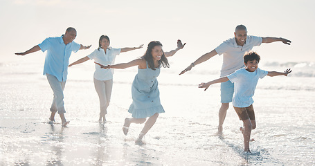 Image showing Travel, beach and happy family running together at the sea or ocean bonding for love, care and happiness. Summer, sun and parents with children or kids and grandparents on a holiday for freedom