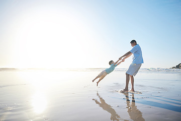 Image showing Family, father and spinning a child at the beach for fun, adventure and play on holiday. A man and young kid holding hands on vacation at the ocean, nature or outdoor with mockup banner space in sky