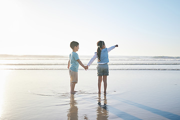 Image showing Beach, travel and back of children holding hands while on a vacation, holiday or adventure. Freedom, love and kid siblings playing and bonding together by the ocean on a tropical summer weekend trip.