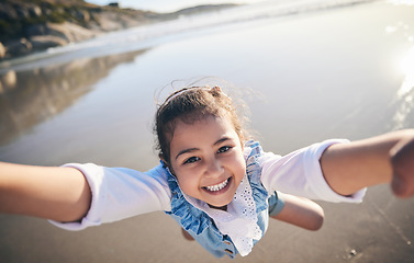 Image showing Person, spinning girl and pov at beach, portrait and smile for game, excited face and playing by sea in sunshine. Parent, young child and swing with speed, love or bonding with holding hands by ocean