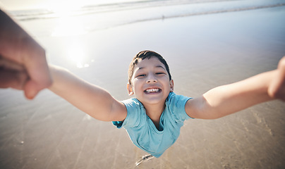 Image showing Person, spin kid and pov at beach, portrait and smile for game, excited and playing by water in sunshine. Parent, young boy child and swing with speed, love and bonding with holding hands by ocean