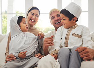 Image showing Happy family, Islam and laughing on couch for Eid with mom, dad and kids with home culture in Indonesia. Muslim man, woman in hijab and children smile, funny bonding on sofa together in living room.