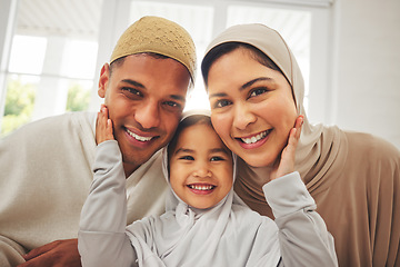 Image showing Islam, portrait and smile, parents and kid in living room for Eid with mom, dad and daughter with home culture. Face of Muslim man, woman in hijab and child in Ramadan on sofa together in Indonesia.