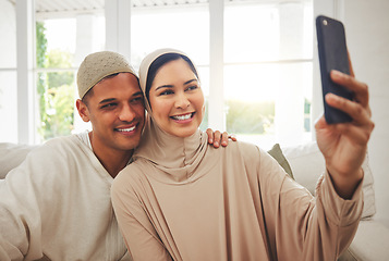 Image showing Selfie, Islam and happy couple on couch with smile, culture and love in living room in Indonesia. Marriage, man and woman in hijab on sofa together with respect, religion and photo for social media.