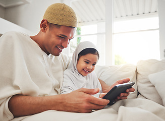 Image showing Family, tablet or study with a father and muslim girl on a sofa in the living room of their home together for e learning. Kids, education or child development with a man teaching his student daughter