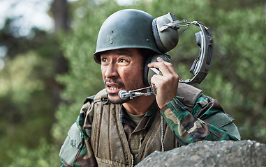 Image showing Army, battle and a man with a headset for communication in a field, help or call for danger. Veteran, hero and a person in the military with gear for support, talking or advice in nature for safety