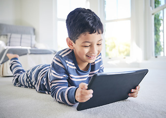 Image showing Young boy, tablet and games or cartoon streaming online with internet, e learning and relax on carpet in house. Watch animation film, male kid at home and connection, entertainment and subscription