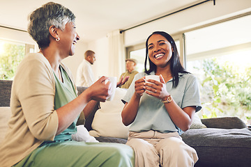 Image showing Woman drinking a cup of coffee with her senior mother while laughing, talking and bonding at home. Happy, smile and elderly female person enjoying a cappuccino with her adult daughter in living room.