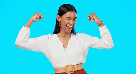 Image showing Business woman, arm flex and happy face of a Indian female feeling power, succes and win. Work victory, champion and confident young employee in a studio with isolated blue background and a smile