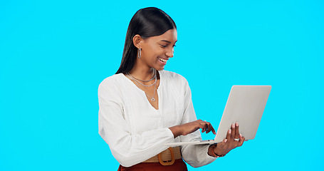 Image showing Business woman, laughing and laptop in a studio reading a funny email on computer. Isolated, blue background and young Indian female with happiness writing on a website with a smile feeling happy