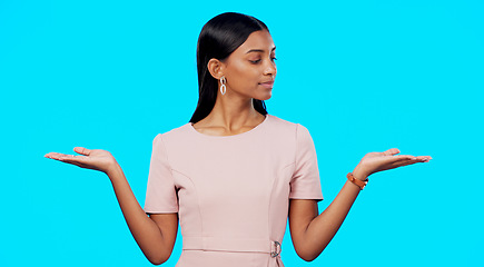 Image showing Choice, option or decision and a woman on a blue background in studio with a hand gesture. Portrait, balance and scale with an attractive young female weighing up the pros and cons of a variable