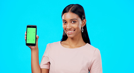 Image showing Chroma key, green screen and woman holding phone with mockup for logo, branding and mobile app advertising. Smile, happy and portrait of professional female isolated in a studio blue background