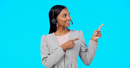 Image showing Call center, portrait or happy woman in studio pointing for promotion or product placement on blue background. Smile, mockup space or Indian girl in headset at technical support or customer services