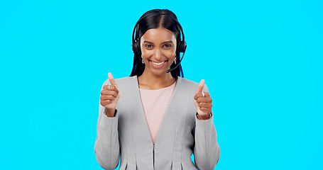 Image showing Call center, portrait or happy woman with thumbs up in studio for agreement on blue background. Smile, mockup space or Indian girl with like, success or yes hand sign at telecom crm customer services