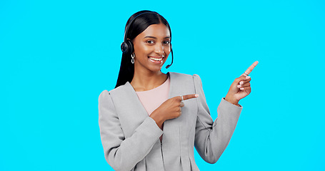 Image showing Call center, portrait or happy woman in studio pointing for promotion or product placement on blue background. Smile, mockup space or Indian girl in headset at technical support or customer services