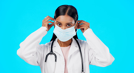 Image showing Studio woman, face mask and covid doctor, female surgeon or nurse for disease support, healthcare or pandemic help. Hospital policy compliance, safety portrait or medical person on blue background