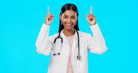 Image showing Hospital doctor, studio and happy woman point at medical promotion, healthcare notification or clinic announcement mockup. Nurse portrait, advertising surgeon and marketing person on blue background