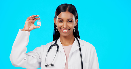 Image showing Studio woman, vaccine and happy doctor, female surgeon or nurse with covid 19, monkeypox or disease cure. Medical portrait, medicine bottle container or science hospital innovation on blue background