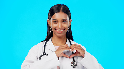 Image showing Heart gesture, happy woman and medical doctor, surgeon or nurse care for support, medicine healthcare or cardiology health. Emoji love sign, studio portrait or hospital female help on blue background