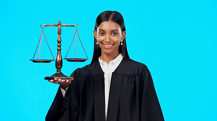 Image showing Portrait, balance scale or happy woman lawyer in studio for justice system, career services or marketing. Fair legal worker, mockup space or trusted Indian girl attorney with smile on blue background