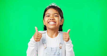 Image showing Portrait, children and thumbs up with a girl on a green screen background in studio wearing a princess tiara. Kids, thank you and emoji with an adorable little girl child saying yes in agreement