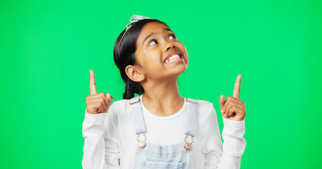 Image showing Green screen, mockup and child pointing up excited, happy and isolated in a studio background. Deal, sale and young girl or kid hands showing at brand, product placement or branding logo
