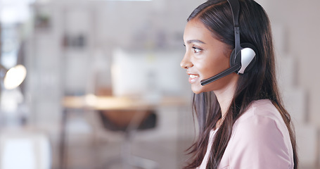 Image showing Call center or customer support agent talking to a client using headphones while sitting and working inside. Remote worker offering great service, advice and explaining a product or insurance plan