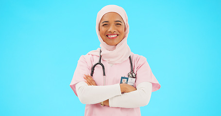 Image showing Muslim woman, face and nurse smile with arms crossed in studio isolated on blue background mockup. Portrait, medical professional and confident, happy and proud Islamic person or surgeon from Turkey.